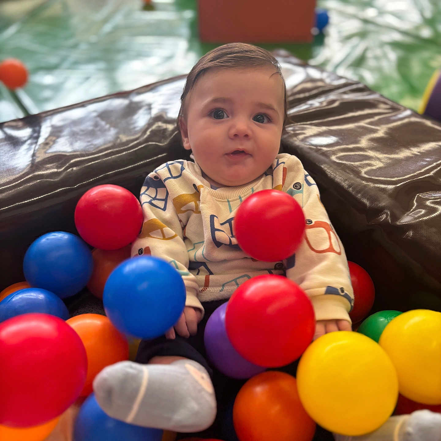 Cali participe au concours pour gagner de l'argent avec cette photo : baby, blue_ball, child, clothing, colorful_balls, cute, expression, fun, indoor, infant, orange_ball, play_area, portrait, purple_ball, red_ball, sitting, socks, soft_play, toy, yellow_ball