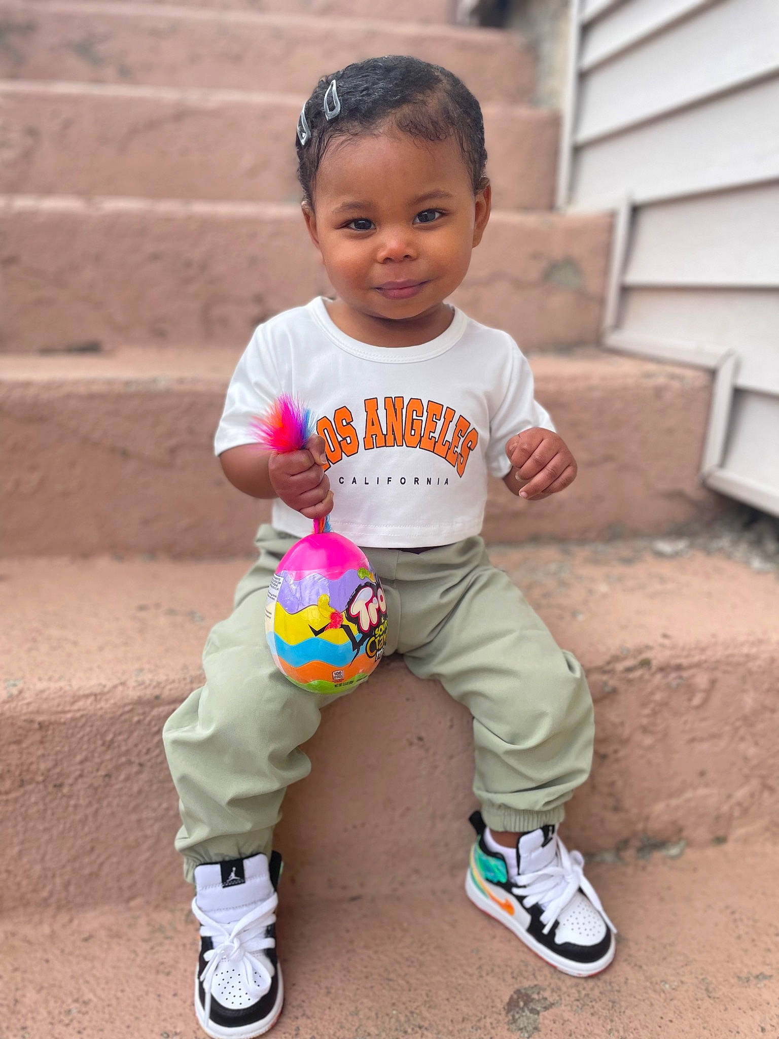 Ohana is registered to the contest to win money with this photo: baby, baby_toddler_clothing, child, fun, grass, hairstyle, happy, joy, leisure, person, pink, play, recreation, sitting, sleeve, smile, sneakers, sock, soil, sports_toy