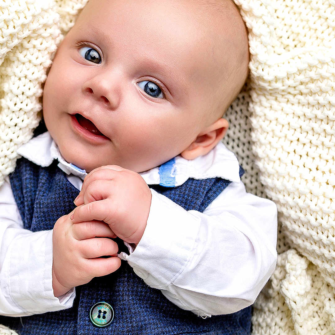 Robert joined the competition — help win amazing prizes! baby, infant, blue_eyes, knitted_blanket, white_shirt, vest, hands, smile, portrait, closeup, cute, child, skin, face, head, cozy, warm, young, happy, indoor