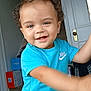 Andrew joined the competition — help win amazing prizes! child, toddler, smiling, curly_hair, blue_shirt, nike_logo, indoor, door, boxes, floor, person, happy, face, head, earring, young_child, reaching, light, casual_clothing, home