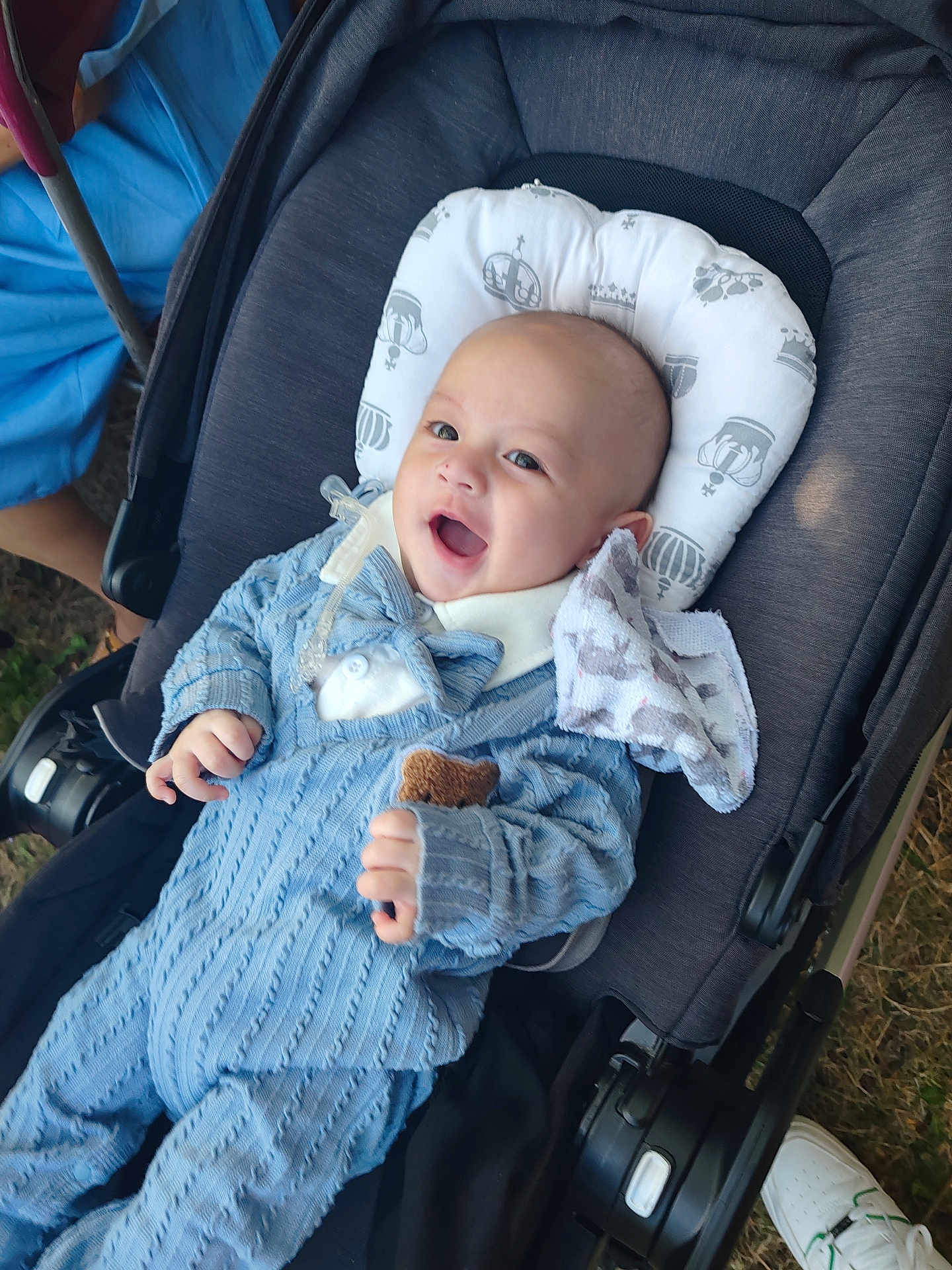 Max joined the competition — help win amazing prizes! baby, smiling, stroller, blue_knit_outfit, pillow, toy, hand, face, outdoor, grass, footwear, white_shoe, fabric, head_support, happy, infant, child, person, cute, cozy