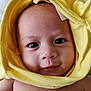 baby, child, face, eyes, smile, yellow_cloth, skin, curious, infant, portrait, headwear, cute, expression, indoors, blanket, young, human, closeup, adorable, happy