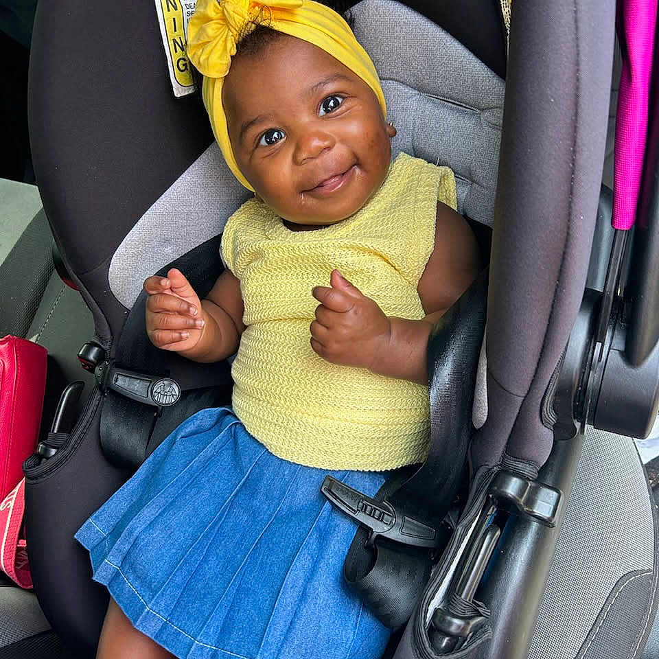 Jay'Anna Clay joined the competition — help win amazing prizes! accessories, baby, car, car_interior, carseat, clothing, dress, face, happy, hat, head, person, photography, portrait, sitting, skirt, sleeve, smile, transportation, vehicle