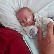 Joseph joined the competition — help win amazing prizes! newborn, baby, infant, sleeping, hospital, pillow, hand, medical_tube, white_clothing, bed, blanket, person, resting, indoors, soft_light, care, healthcare, gentle_touch, comfort, closeup