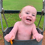 Wesley is registered to the contest to win money with this photo: toddler, baby, child, swing, playground, grass, outdoor, smiling, happy, park, hand, face, skin, toy, nature, play, seat, daytime, person, fun