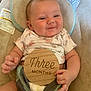 baby, infant, child, smiling, floral_onesie, wooden_sign, three_months, cushioned_seat, diaper, hand, face, head, skin, happy, cute, indoors, portrait, young_child, comfort, baby_seat