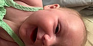 Wisteria is registered to the contest to win money with this photo: baby, bed, cheek, child, closeup, clothing, ear, eye, fabric, face, green, head, infant, lying_down, mouth, nose, pillow, skin, smile, soft