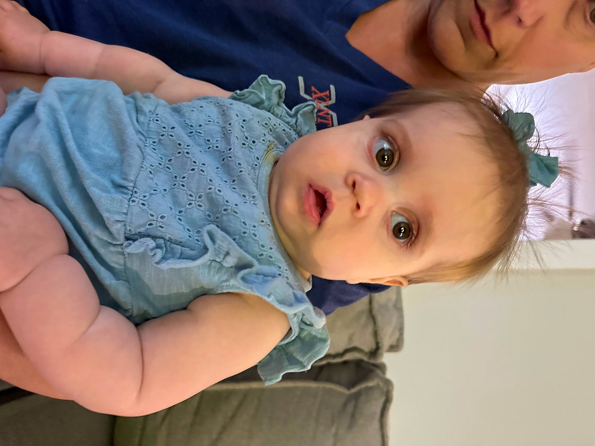Hannah is registered to the contest to win money with this photo: arm, baby, baby_toddler_clothing, cheek, child, chin, dress, eye, eyelash, face, hand, happy, human_body, iris, lip, nose, person, plant, skin, sleeve