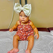 Malaysia joined the competition — help win amazing prizes! baby, child, headband, bow, romper, floral, sitting, barefoot, medical_table, paper_cover, curious, indoors, skin, legs, arms, cute, expression, infant, person, portrait