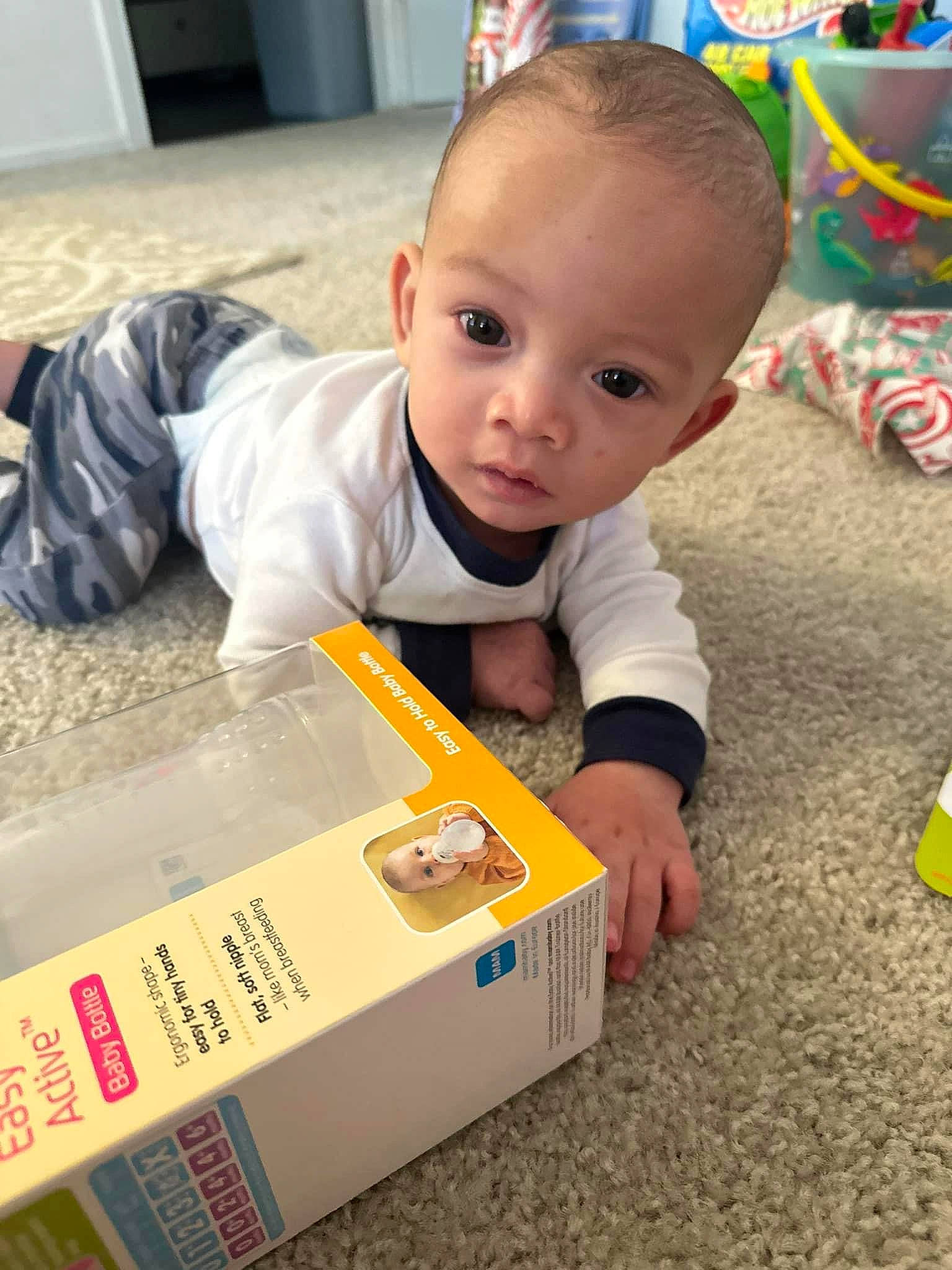 Eziah is registered to the contest to win money with this photo: baby, baby_toddler_clothing, box, cabinetry, carton, child, crawling, floor, flooring, fun, hardwood, learning, packaging_and_labeling, packing_materials, person, play, room, shipping_box, sitting, toddler