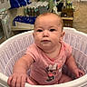 baby, child, infant, shopping_basket, store, retail, indoors, portrait, sitting, pink_shirt, smiling, face, person, shelves, products, shopping, grocery_store, hand, cute, photography