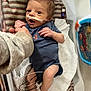 Silas is registered to the contest to win money with this photo: baby, newborn, hospital, crib, medical_tubes, wristband, blue_onesie, fox_emblem, blanket, hand_holding, medical_equipment, infant, person, cute, healthcare, small, lying_down, striped_blanket, indoor, closeup