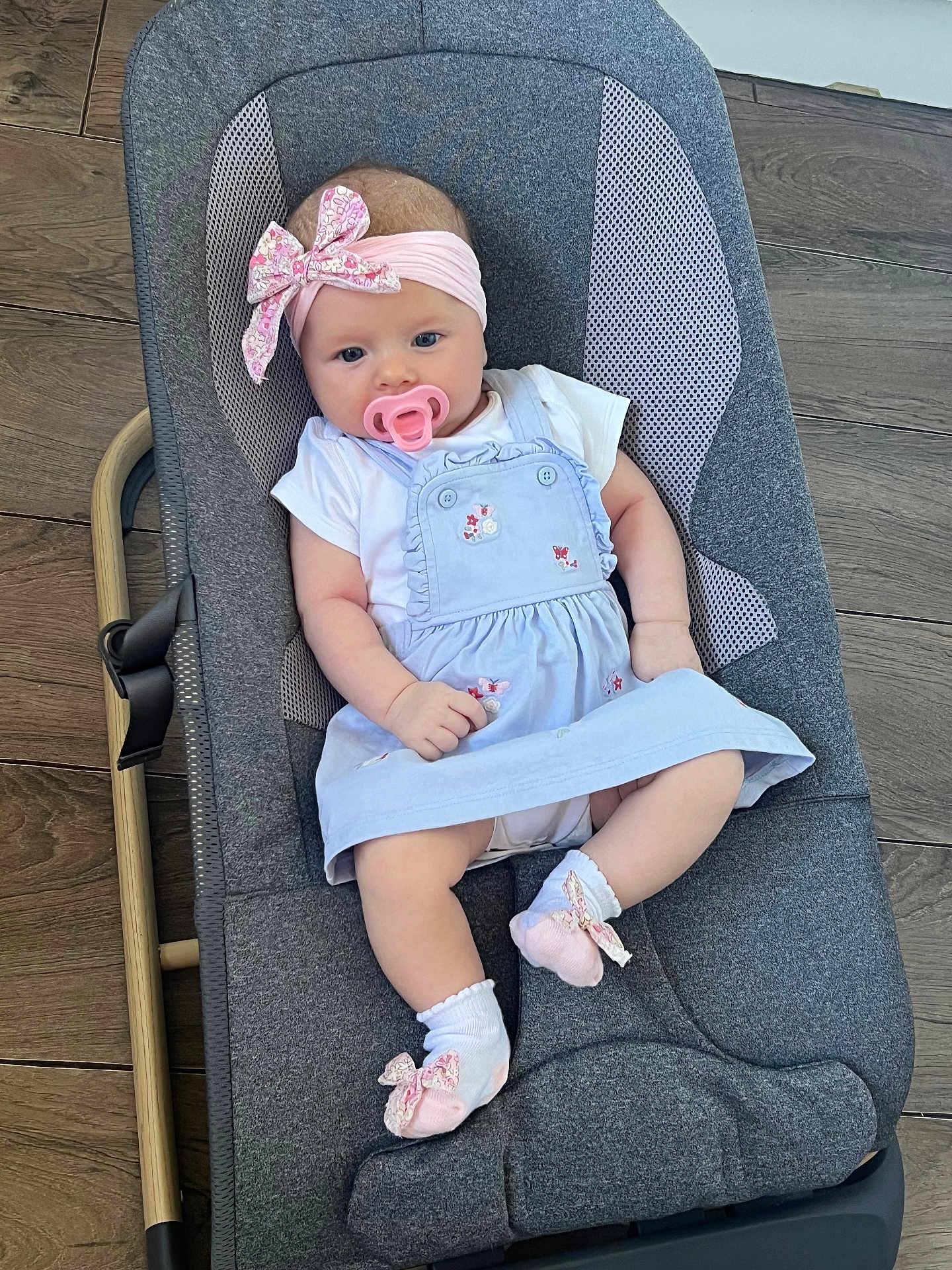Adriana joined the competition — help win amazing prizes! baby, infant, pacifier, headband, bow, dress, blue_dress, socks, pink_socks, baby_rocker, gray_rocker, wooden_floor, cute, child, person, indoor, comfort, clothing, portrait, relaxing