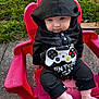 Amelia joined the competition — help win amazing prizes! baby, child, hoodie, black_clothing, gaming, controller_design, pout, plastic_chair, red_chair, outdoor, grass, concrete, cute, chubby_cheeks, sitting, footwearless, young_child, portrait, casual, playful