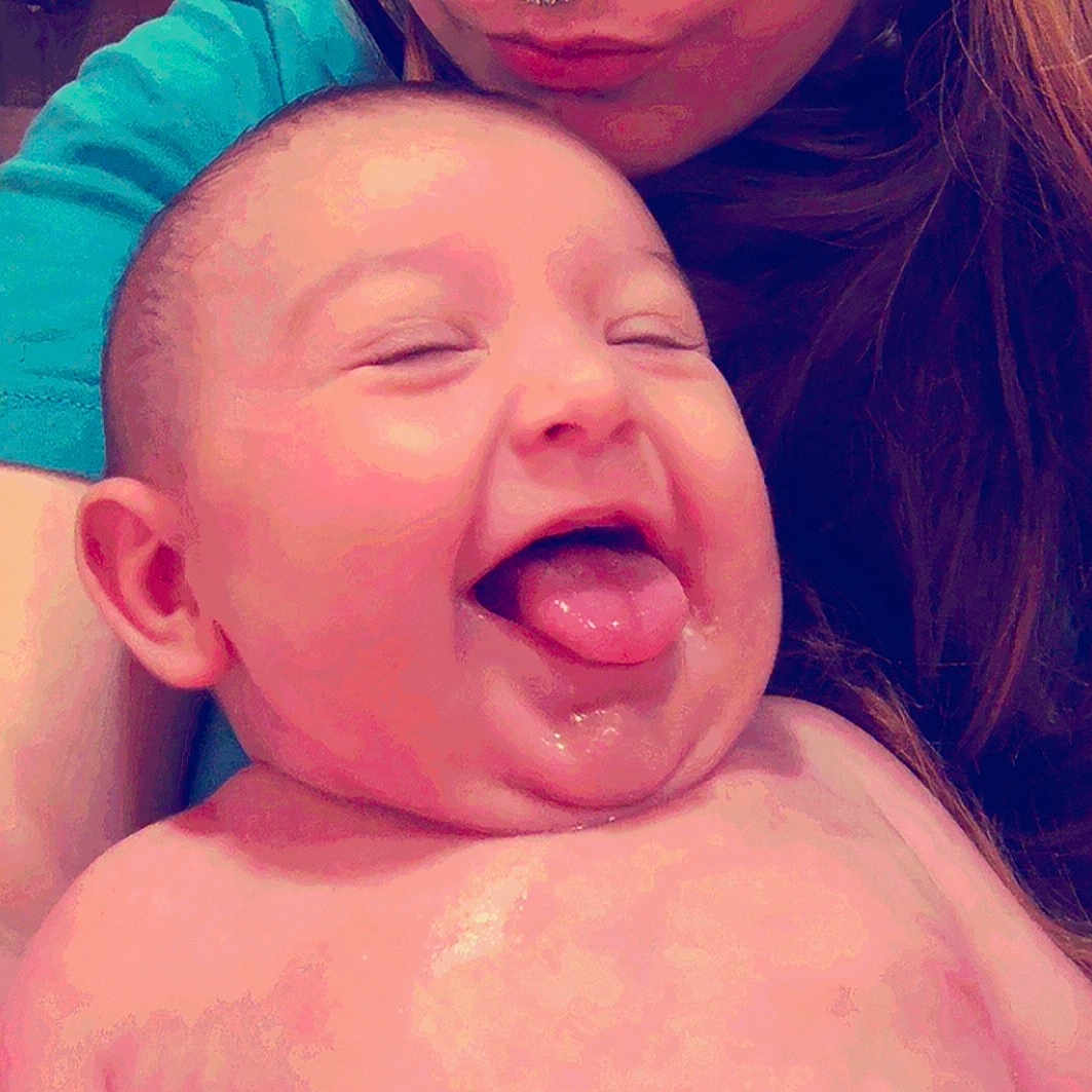 Amelia is registered to the contest to win money with this photo: adult, baby, cheerful, child, closeup, cute, expression, face, hair, happy, head, holding, human, infant, joyful, person, portrait, skin, smiling, tongue_out