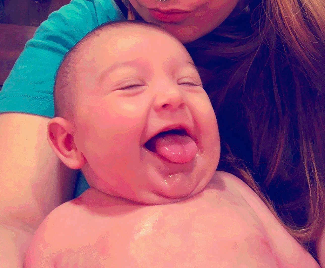 Amelia is registered to the contest to win money with this photo: baby, tongue_out, smiling, happy, child, person, face, skin, head, hair, adult, holding, closeup, expression, joyful, cute, human, portrait, infant, cheerful