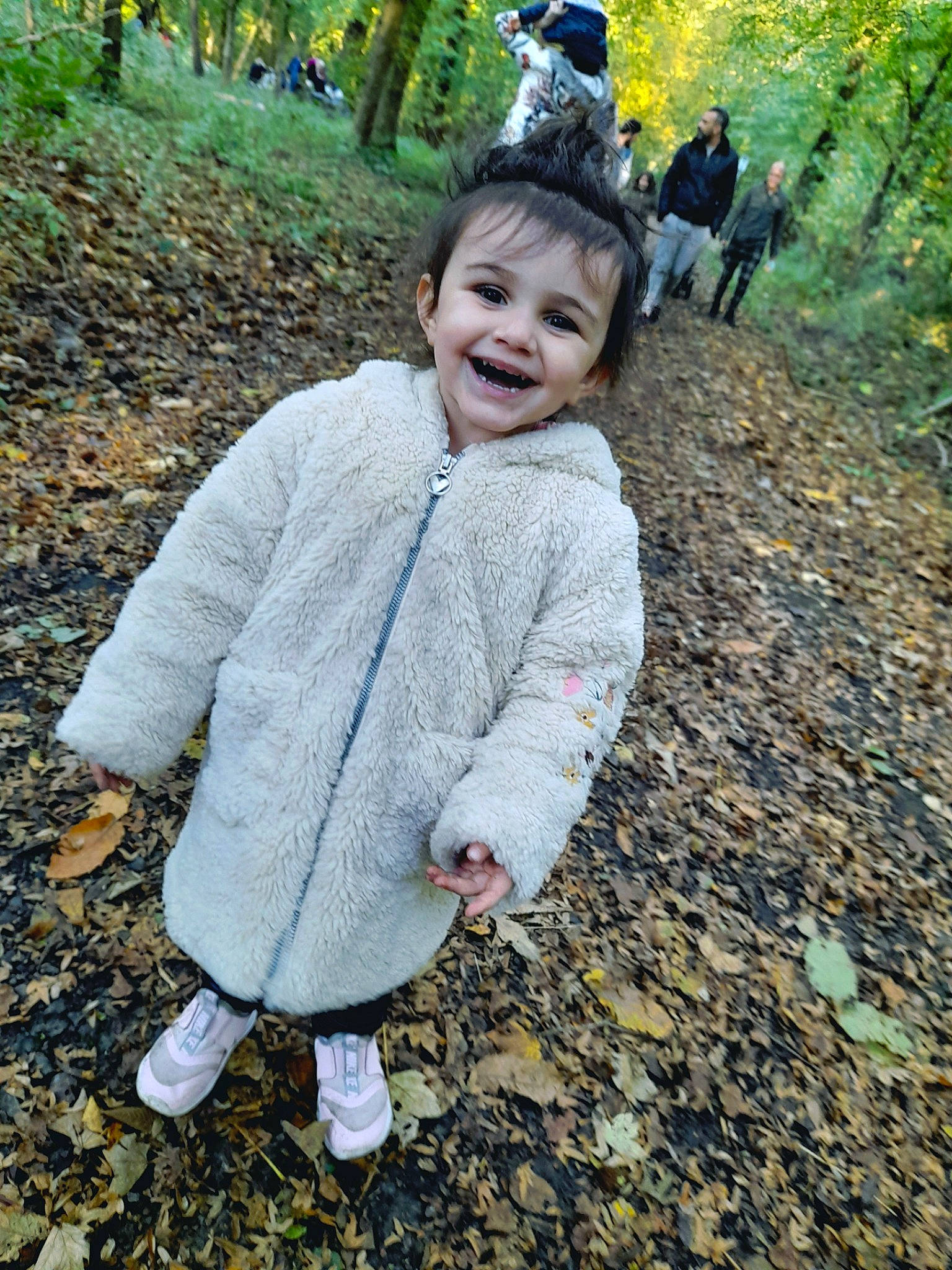 Gina a rejoint le concours — aidez-le/la à gagner de superbes lots ! baby_toddler_clothing, blurred, child, clothing, forest, fun, grass, happy, jacket, joy, leaf, leisure, outerwear, people_in_nature, person, plant, recreation, sleeve, smile, soil