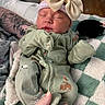 newborn, baby, sleeping, onesie, bow, hat, tattoo, hand, blanket, green, cozy, infant, cute, soft, resting, clothing, pattern, animal_print, indoor, portrait