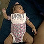 Leilani is registered to the contest to win money with this photo: accessories, baby, bed, bodypart, clothing, couch, cushion, diaper, dress, face, finger, furniture, hand, head, homedecor, newborn, person, photography, portrait, shorts