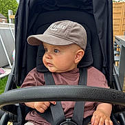 Izak participe au concours pour gagner de l'argent avec cette photo : baby, child, stroller, cap, harness, outdoor, greenery, wooden_fence, curious, casual_clothing, brown_shirt, shorts, baby_hand, seat, baby_face, summer, daylight, park, baby_boy, infant