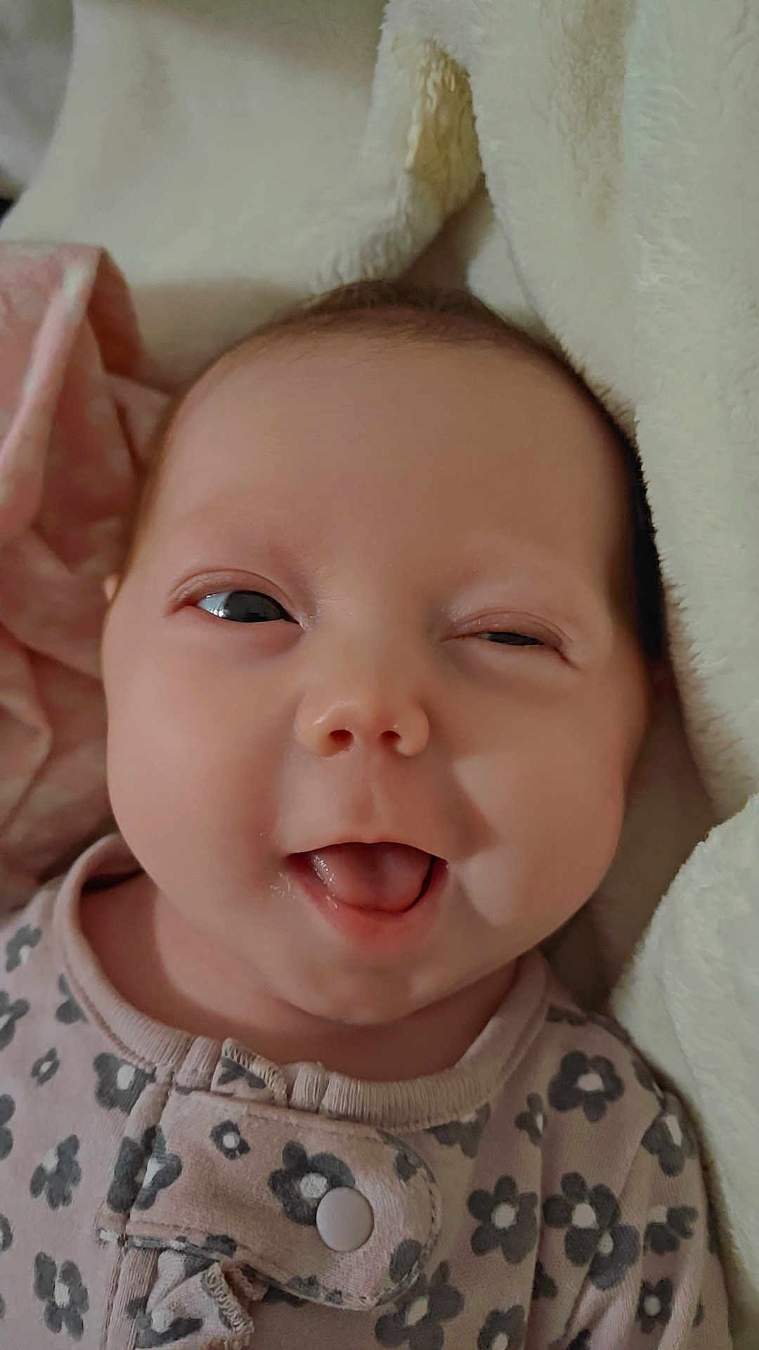 Alaysha joined the competition — help win amazing prizes! baby, infant, newborn, smiling, tongue_out, onesie, blanket, close_up, face, rosy_cheeks, eyes, portrait, soft_texture, cozy, sleepwear, nursery, cute, skin, head, happy