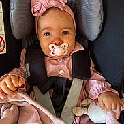 Lyna a rejoint le concours — aidez-le/la à gagner de superbes lots ! baby, child, pacifier, headband, pink_clothing, car_seat, safety_harness, plush_toy, blanket, infant, cute, portrait, indoor, face, hands, button, fabric, soft_toy, smile, young