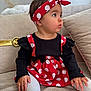 toddler, child, baby, sitting, dress, headband, polka_dot, red, white, black, long_sleeve, sock, couch, pillow, indoor, cute, portrait, face, hand, cozy