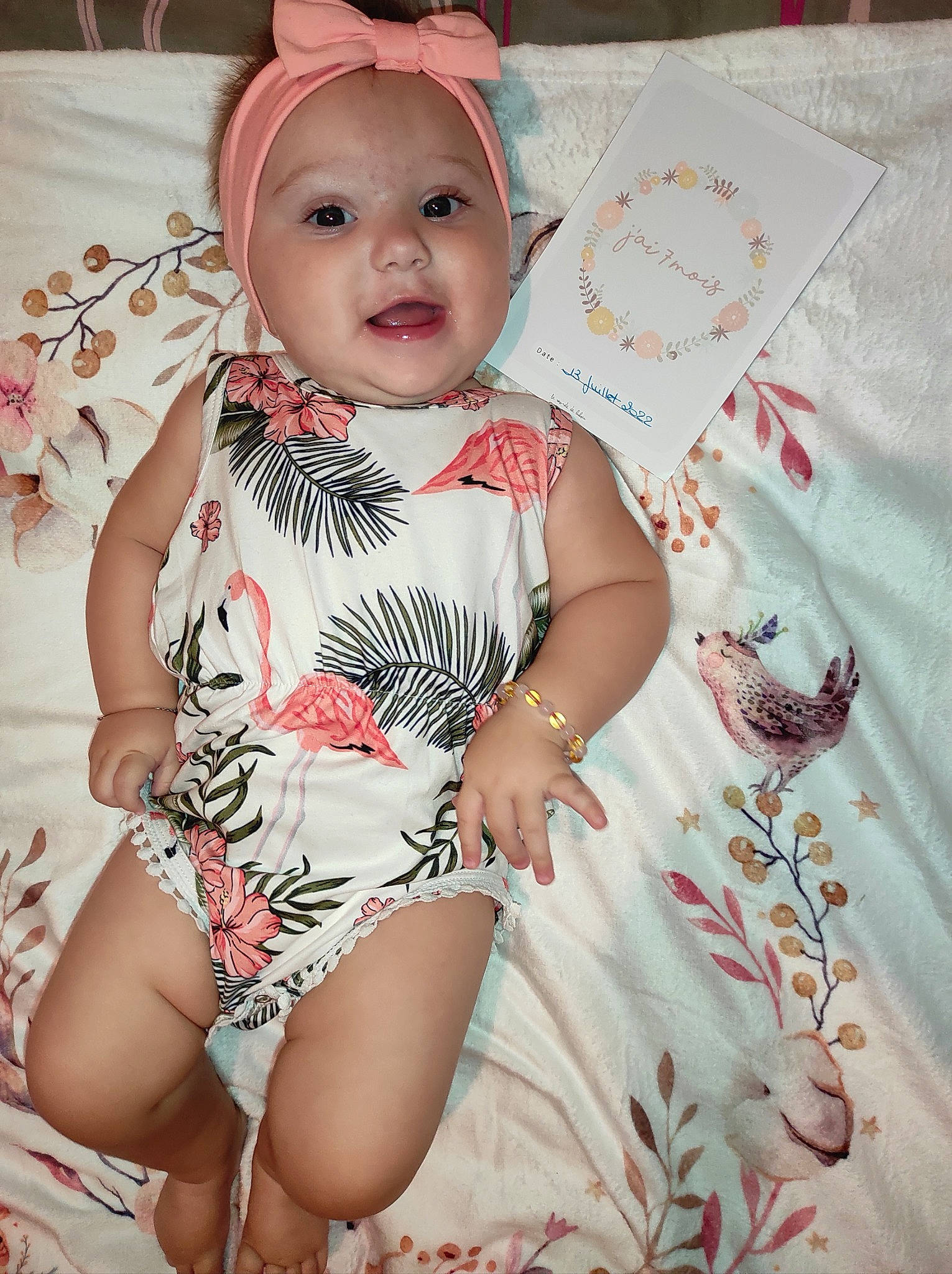 Naëlya participe au concours pour gagner de l'argent avec cette photo : baby, baby_toddler_clothing, child, day_dress, dress, eye, face, happy, head, headwear, human_leg, jewellery, lip, pattern, person, pink, sitting, skin, sleeve, smile