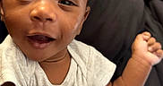 Keziah is registered to the contest to win money with this photo: baby, bed, blanket, child, clothing, cute, face, hand, happy, indoors, infant, pants, person, pillow, portrait, room, shirt, skin, smiling, young