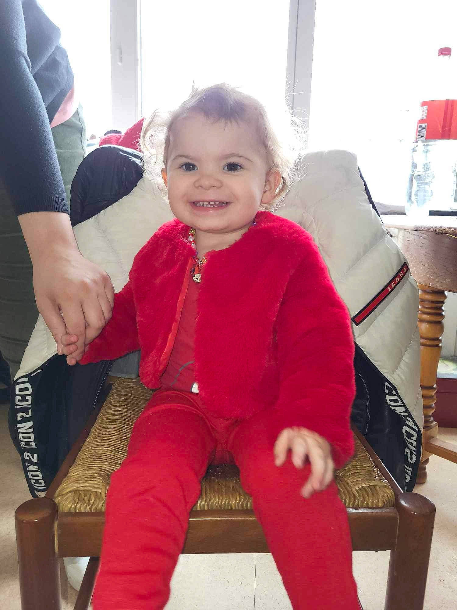 Léa participe au concours pour gagner de l'argent avec cette photo : baby, baby_toddler_clothing, chair, cheek, comfort, finger, furniture, gesture, happy, joint, joy, knee, lap, leg, mammal, person, skin, sleeve, smile, standing