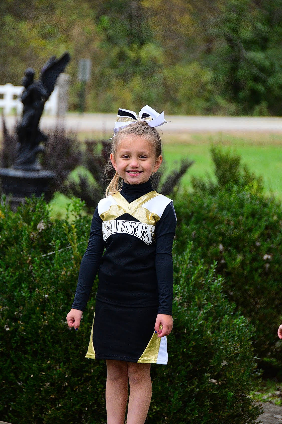 Karlee is registered to the contest to win money with this photo: baby_toddler_clothing, child_model, costume_accessory, day_dress, dress, embellishment, garden, hair_accessory, headband, headpiece, joy, one_piece_garment, person, sculpture, shrub, toddler, yard