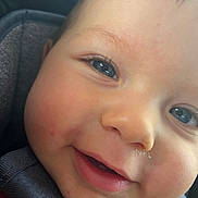 Liam is registered to the contest to win money with this photo: child, toddler, baby, face, portrait, close_up, blue_eyes, smiling, curious, rosy_cheeks, car, car_seat, seatbelt, vehicle, indoor, daylight, skin, eyes, nose, photography