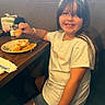 Olivia joined the competition — help win amazing prizes! child, smiling, restaurant, booth, sitting, food, plate, pasta, vegetables, meal, table, dining, indoor, portrait, long_hair, white_shirt, shorts, happy, face, photograph