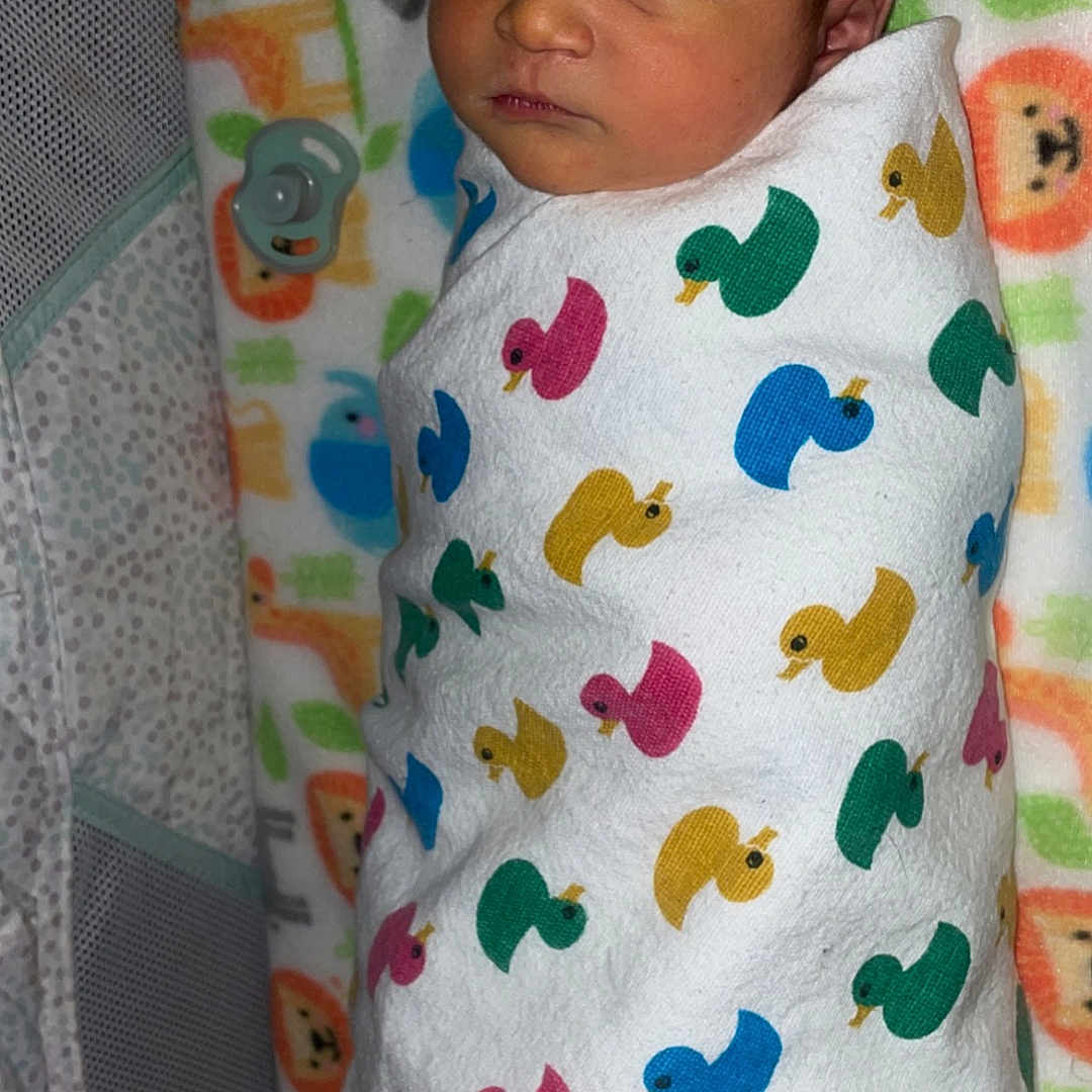 Christopher is registered to the contest to win money with this photo: applique, architecture, baby, bed, bedroom, blanket, building, cradle, crib, cushion, face, furniture, head, homedecor, hospital, indoors, infantbed, newborn, pattern, person