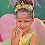 Hailey is registered to the contest to win money with this photo: child, costume, cute, decor, face, girl, glitter, green_dress, hand, happy, indoor, pink_chair, portrait, posing, princess, seated, smile, sparkles, tiara, young_child