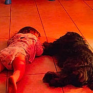 Davina is registered to the contest to win money with this photo: baby, barefoot, black_dog, child, cozy, cute, dog, floor, friendship, home, indoor, lying_down, orange_light, pajamas, pet, quiet, relaxing, sleeping, tile, together