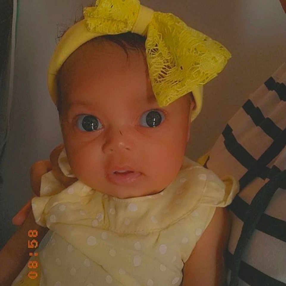 Deja is registered to the contest to win money with this photo: baby, baby_products, baby_toddler_clothing, cap, cheek, chin, costume_hat, dress, eye, eyebrow, fashion_accessory, hairstyle, head, headgear, lip, nose, room, sleeve, toddler, white