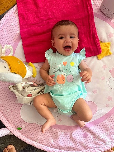 Lya participe au concours pour gagner de l'argent avec cette photo : baby, baby_toddler_clothing, chair, cheek, child, comfort, eye, face, fun, happy, lap, linens, person, pink, sitting, skin, sleeve, smile, t_shirt, thigh