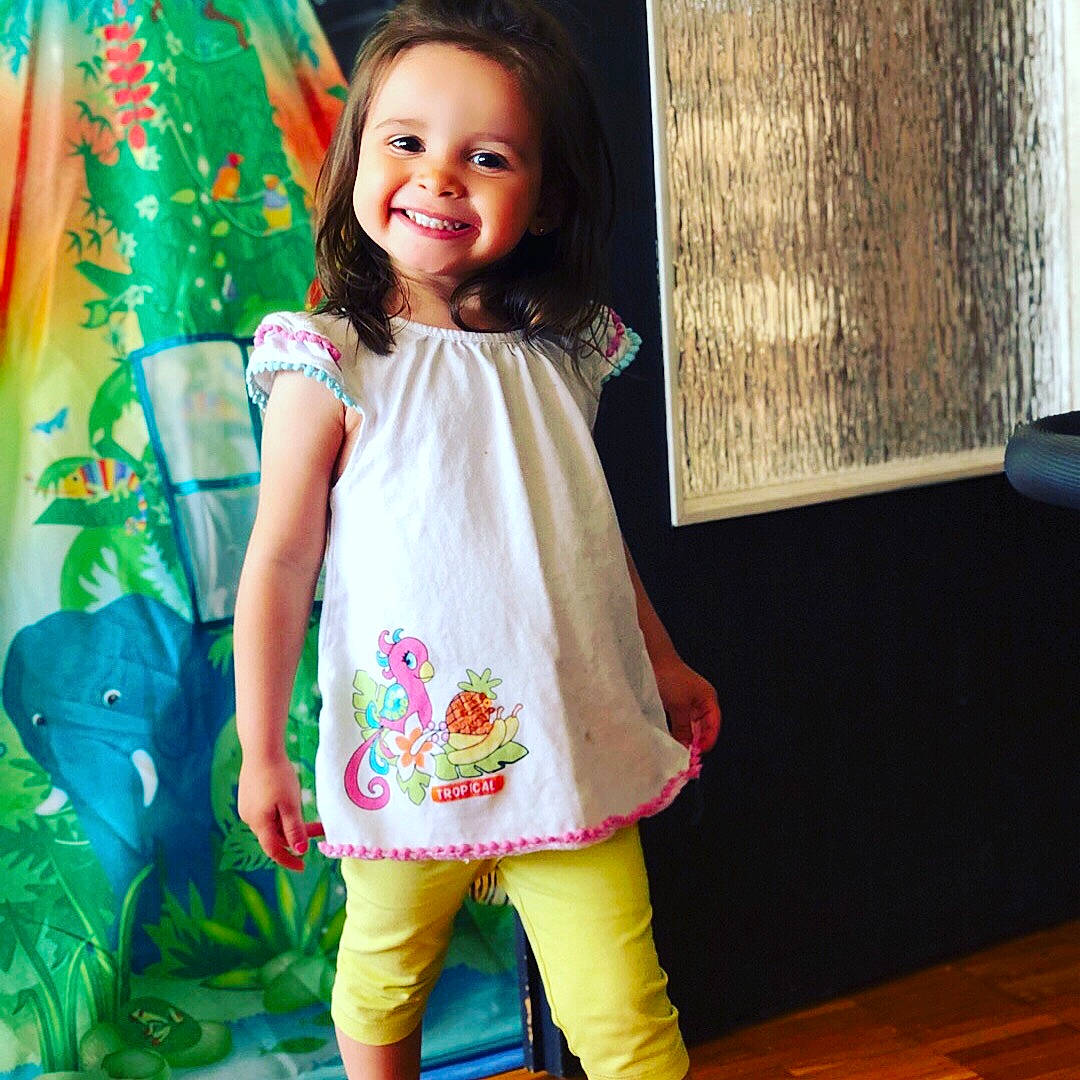 Inês participe au concours pour gagner de l'argent avec cette photo : child, child_model, clothing, design, dress, embroidery, fashion_design, joy, leggings, neck, outerwear, pattern, person, pink, sleeve, smile, textile, tights, toddler, yellow
