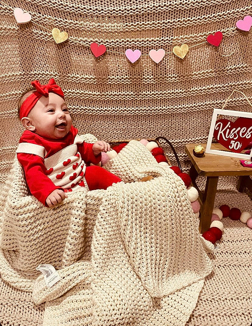 Briella joined the competition — help win amazing prizes! baby, baby_toddler_clothing, carmine, christmas, christmas_eve, comfort, couch, event, flooring, fur, headwear, holiday, linens, ornament, pattern, person, red, room, sitting, textile