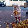 child, toddler, autumn, leaves, fall, coat, hat, street, sidewalk, stroller, car, building, window, tree, outdoor, footwear, pants, scarf, person, daytime