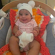 Samadhi is registered to the contest to win money with this photo: baby, child, infant, smiling, happy, portrait, indoor, crib, hat, bear_hat, pink_clothing, knitted_blanket, soft_toy, toy, seated, cozy, colorful, nursery, baby_photo, close_up