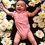 baby, infant, smiling, pink_onesie, white_flowers, floral_arrangement, lying_down, happy, cute, portrait, child, peaceful, arms_outstretched, legs_visible, skin, head, face, nature, soft_lighting, closeup