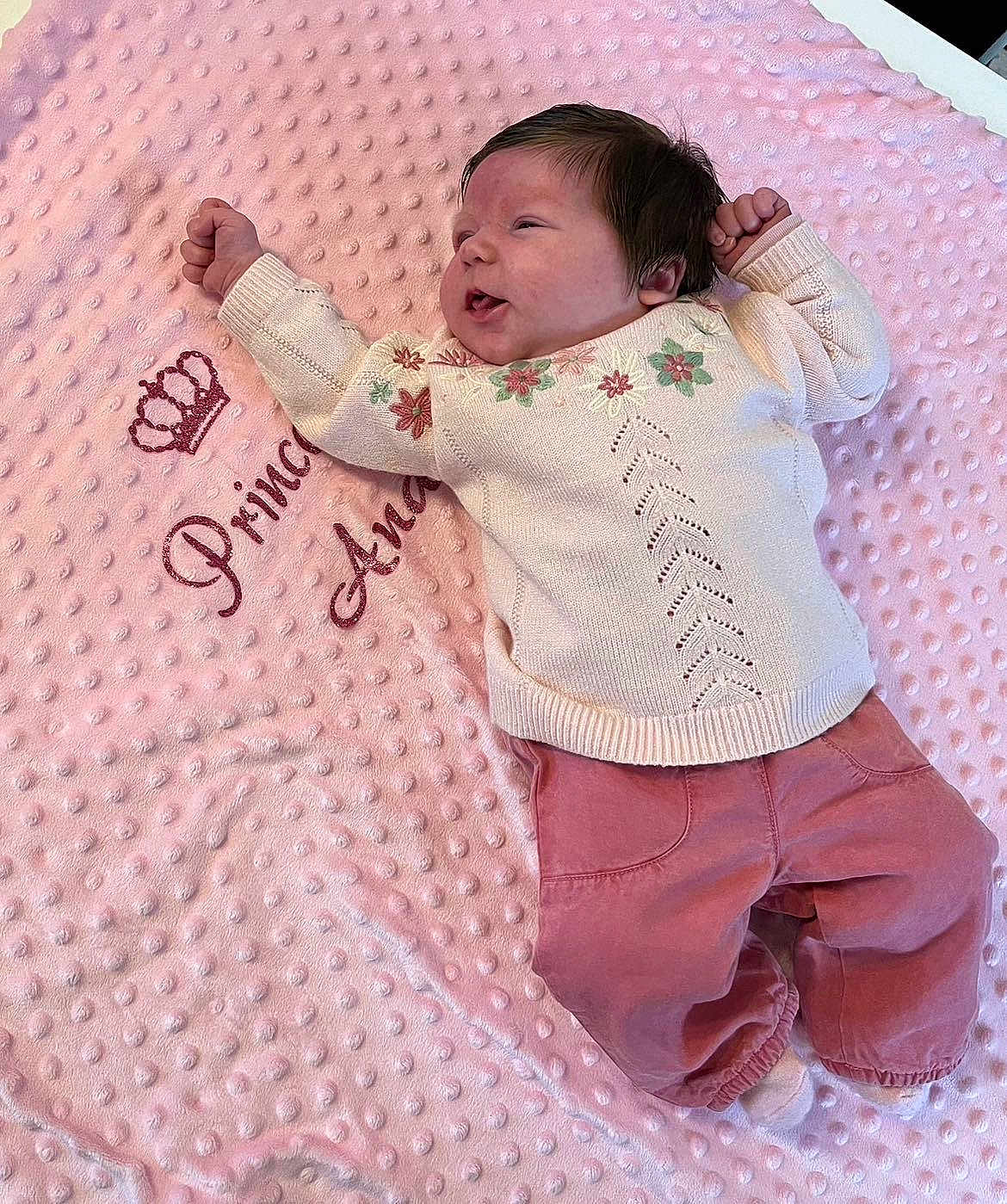 Ana a rejoint le concours — aidez-le/la à gagner de superbes lots ! baby, blanket, pink, sweater, pants, floral, embroidery, crown, text, soft, texture, infant, clothing, cute, lying_down, newborn, child, portrait, indoors, relaxed