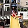 Christopher is registered to the contest to win money with this photo: child, toddler, slide, playground, playhouse, swing, woman, outdoor, daylight, grass, fence, smile, support, red_clothing, yellow_slide, casual_clothing, backyard, tree, fun, family