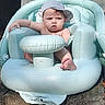 Luke is registered to the contest to win money with this photo: baby, cap, child, cute, daytime, face, foot, hand, infant, inflatable_chair, outdoor, person, relaxing, seat, serious_expression, skin, summer, sunlight, water_droplets, wooden_surface