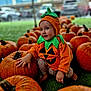 autumn, baby, child, cute, cute_outfit, fall, festive, grass, green, happy, holiday, nature, orange, outdoor, portrait, pumpkin, pumpkin_costume, seasonal, sitting, smiling