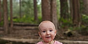 Mavis joined the competition — help win amazing prizes! baby, barefoot, child, cute, daylight, exploration, floral_pants, forest, ground, happy, leaf, nature, outdoor, pink_shirt, sitting, smiling, stick, trees, woodland, young_child