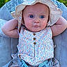 baby, child, infant, hat, floral_dress, seat, cushion, outdoor, grass, blue_eyes, relaxed, sunhat, cute, person, portrait, summer, childcare, baby_clothing, sitting, nature