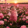 child, girl, rose_field, pink_dress, flower_petals, sunset, nature, smiling, joyful, outdoor, greenery, veil, barefoot, plants, flower, portrait, happiness, spring, blossom, scenery
